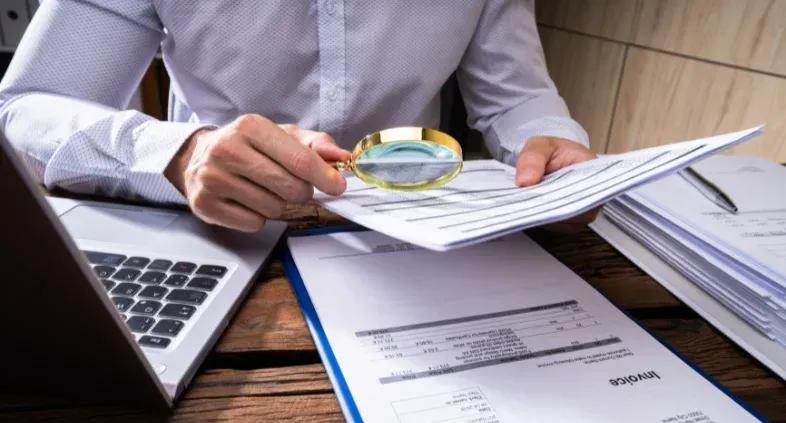 Person reviewing documents to detect fraudulent activity with fraud detection tools